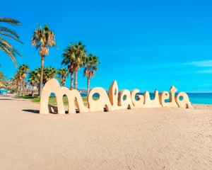 a sign on the beach with palm trees in the background at Malagueta Loft & Sea in Málaga