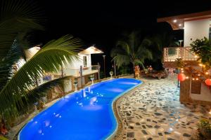 a large blue swimming pool next to a building at Homestay Minano in Mock Den +3 photos