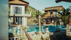 a villa with a swimming pool in a resort at Homestay Minano in Mock Den