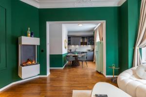 a living room with green walls and a fireplace at Emerald Suite Design in Neumünster in Neumünster +41 photos