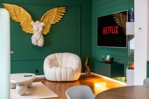 a living room with an angel head on a green wall at Emerald Suite Design in Neumünster in Neumünster