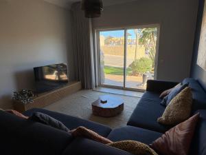 a living room with a blue couch and a tv at Fairviews Boavista , Boavista golf and spa resort Lagos in Lagos