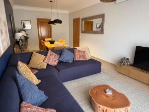 a living room with a blue couch and a table at Fairviews Boavista , Boavista golf and spa resort Lagos in Lagos