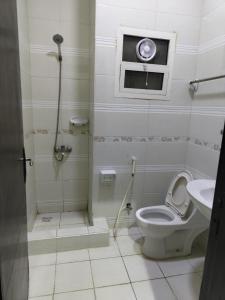 a bathroom with a toilet and a window and a sink at العييري للشقق المخدومة in Dammam
