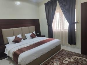 a bedroom with a large bed and a window at العييري للشقق المخدومة in Dammam +11 photos