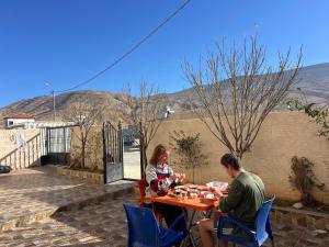 a man and a woman sitting at a table at Beida Bedouin House in Al Ḩayy