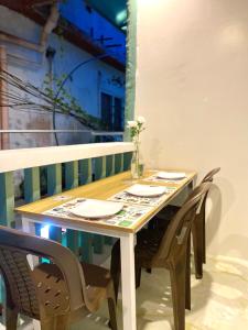 a wooden table with four chairs and a table with plates at Isla Haus Boracay in Boracay