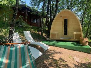 a tent with a hammock in front of a house at Nido di Luna in Mulazzo