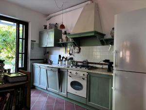 a kitchen with a stove and a white refrigerator at Nido di Luna in Mulazzo