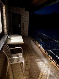 a white table and chair on a balcony at night at ZV38-Alter Weg-OG in Salzgitter