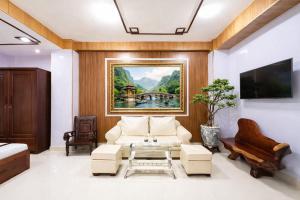 a living room with a couch and a painting on the wall at Diamond Luxury Ben Thanh in Ho Chi Minh City