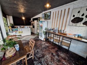 a kitchen with a table and chairs and a refrigerator at Sabai Sabai Bed in Pai
