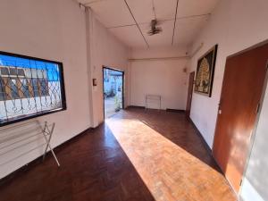 an empty room with a large window and a wooden floor at Sabai Sabai Bed in Pai