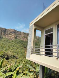 a balcony of a house with a view of a mountain at Cloud Haven in Lāitlyngkot