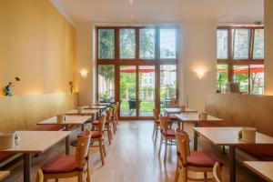 una fila de mesas y sillas en un restaurante en Hotel 26, en Berlín