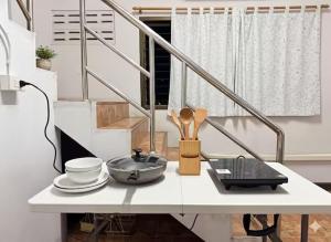 a white table with plates and utensils on it at Saan Stay in Ban Krabi Yai