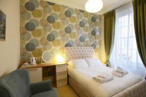 a bedroom with a bed with a desk and a chair at The Devon Court in Torquay +62 photos