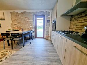 a kitchen with a table and a stone wall at Apartments Casa Sossa in Vilanija