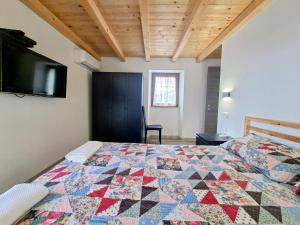 a bedroom with a bed with a quilt on it at Apartments Casa Sossa in Vilanija