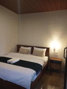 a bedroom with a large bed with white sheets at Traveling Guest House - Shared Kitchen in Kuta Lombok