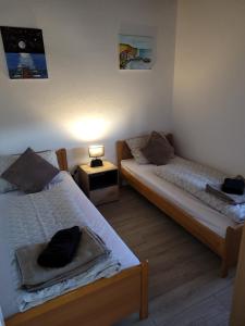 a bedroom with two beds and a night stand with a lamp at Stan na dan BOVKA in Široki Brijeg