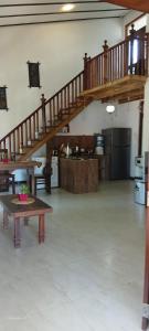a living room with a staircase and a table in a room at Wooden hostel in Weligama