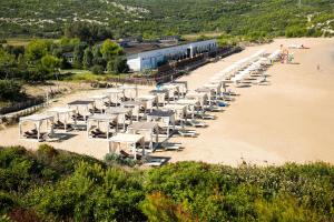 una fila di tavoli e sedie sulla spiaggia di Life Resort Gusmay Beach & SPA - Hotel Cala del Turco a Peschici