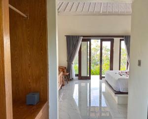 a bedroom with a bed and a door to a room at The Hills Penida in Nusa Penida +2 photos