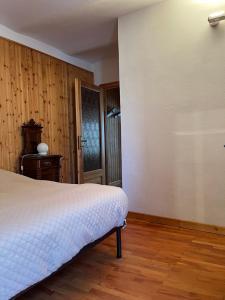 ein Schlafzimmer mit einem Bett und einem Holzboden in der Unterkunft CadlaNona in Boves
