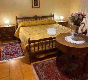 a bedroom with a bed and a table with a vase on it at Casa della Resistenza in Sulmona +7 photos