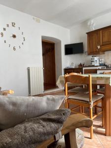 ein Wohnzimmer mit einem Tisch und einer Uhr an der Wand in der Unterkunft CadlaNona in Boves + 1 Foto