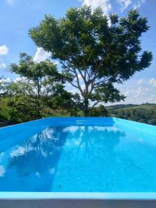 a blue pool with a tree in the background at Cantinho da Paz in Socorro