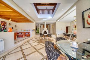 a living room with a glass table and chairs at Villa JUZYAN une parenthèse de bien-être et de convivialité in Marrakesh