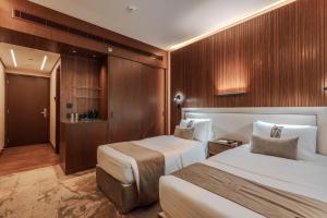a hotel room with two beds and wooden walls at Kuwait Continental Hotel in Kuwait +31 photos