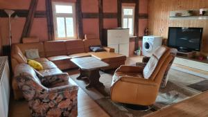 a living room with a couch and chairs and a tv at Wippertaler Hütte in Kleinfurra