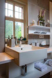 a bathroom with a white sink and a mirror at BLUMEINS - Das Refugium in Groß-Umstadt +53 photos