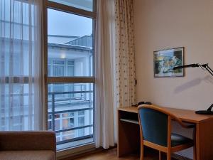 a room with a desk and a large window at Gästehaus Dominikus in Leipzig