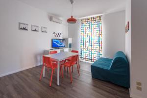 a living room with a table and red chairs at Casa Bratz in Marciana Marina