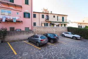 three cars parked in a parking lot next to a building at Casa Bratz in Marciana Marina