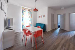 a dining room with a table and red chairs at Casa Bratz in Marciana Marina