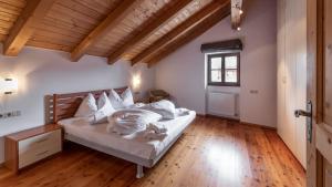 a bedroom with a bed and a wooden floor at Villa Santer in Dobbiaco
