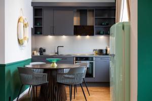 a kitchen with a table and chairs and a refrigerator at Emerald Suite Design in Neumünster in Neumünster