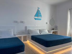 a bedroom with two beds with blue sheets and a sail on the wall at Kleanthi Apartments in Drios