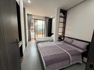 a bedroom with two beds and a balcony at Lien Home in Thôn An Hòa