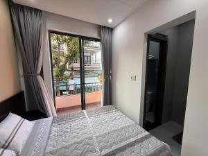 a bedroom with a bed and a large window at Lien Home in Thôn An Hòa