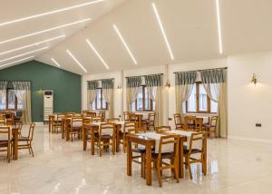 a dining room with wooden tables and chairs at Safir Termal & Spa Otel in Çekirge İstasyonu