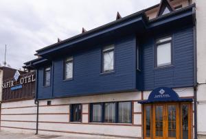 a blue building on the side of a street at Safir Termal & Spa Otel in Çekirge İstasyonu