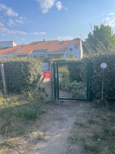 a fence with a gate in front of a house at Maisonnette de Plage in Saint-Hilaire-de-Riez +2 photos