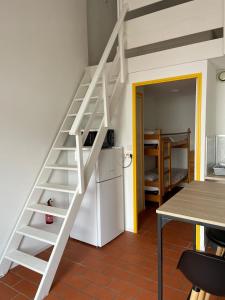a white staircase in a kitchen with a refrigerator at Maisonnette de Plage in Saint-Hilaire-de-Riez