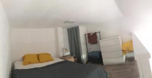 a white bedroom with a bed and a dresser at Maisonnette de Plage in Saint-Hilaire-de-Riez